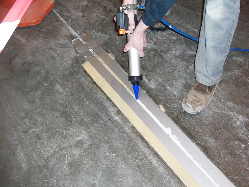 Man repairing a expansion joint so that it is level