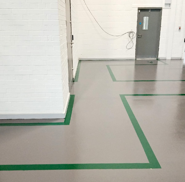Green line marking on grey flooring