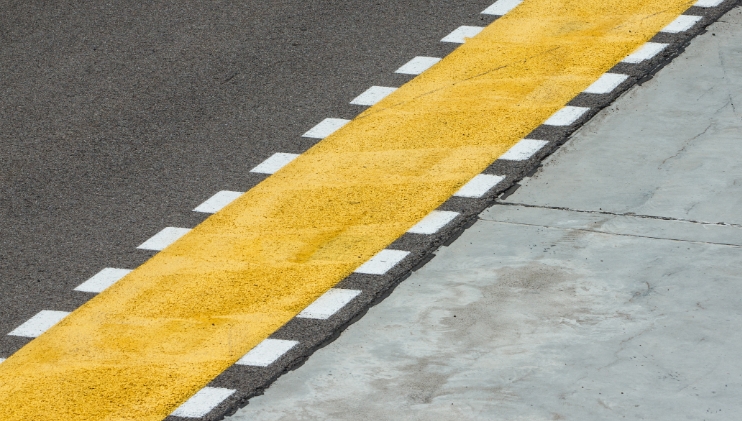 White and yellow painted markings over black tarmac