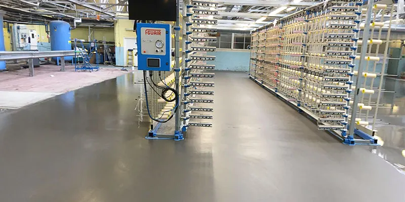 Newly laid resin flooring with pumped screen in a factory.